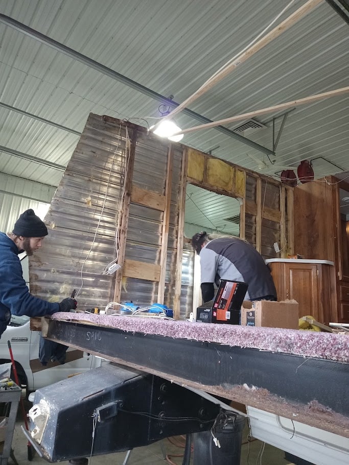 Two people working on RV flooring