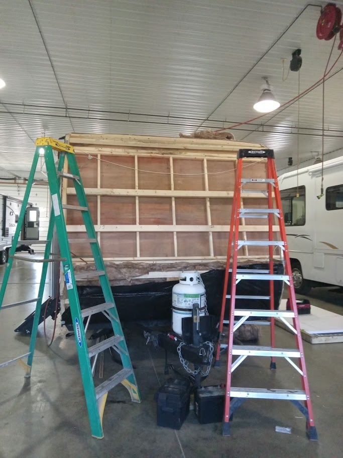 Two ladders repairing back of RV